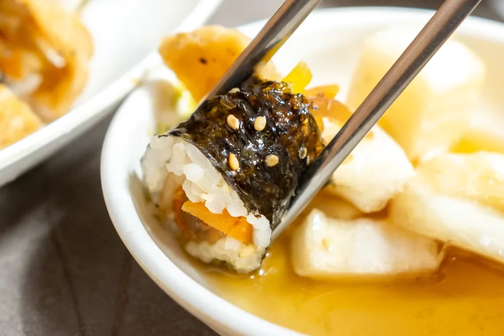 正在沾醬料的小小紫菜飯捲
